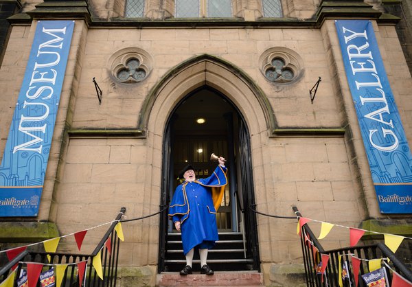 A town crier rings his bell outside the main entrance of Bailiffgate Museum 