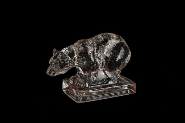 A small glass sculpture of a bear against a black background